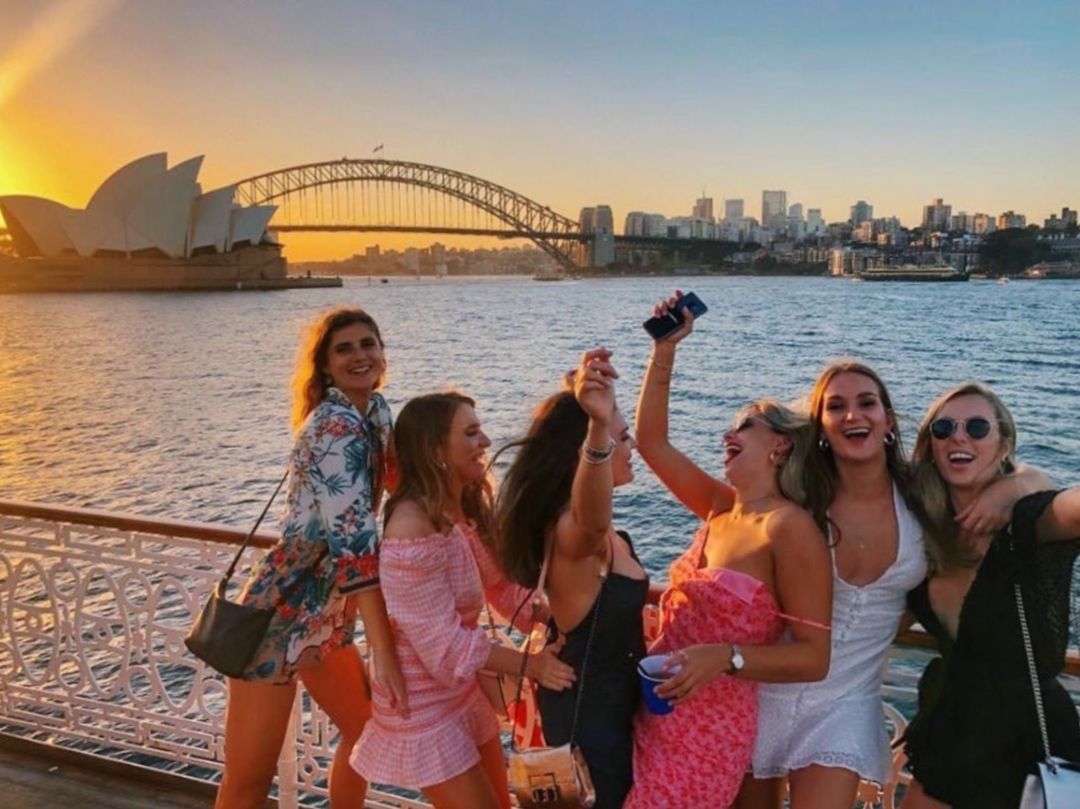 Happy group of girls on boat party in front of Sydney Opera House